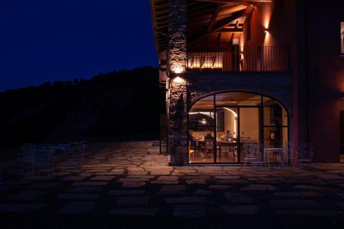 a building with a patio with tables and chairs at night at Relais SANT'AMBROGIO in Bobbio