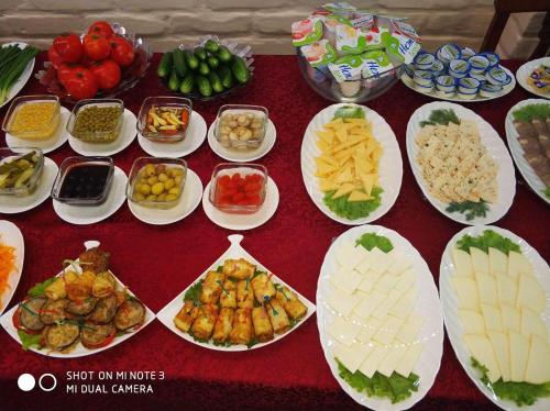 a table full of different types of food on plates at Hotel BEK in Tashkent