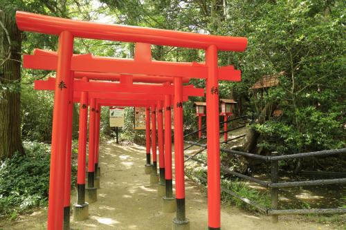 a red torii gate in a park with trees at APA Hotel Fukushima Ekimae in Fukushima