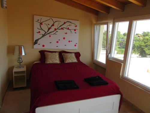 a bedroom with a bed with a red bedspread at Villa Maria Louiza NEAR AIRPORT in Artemida