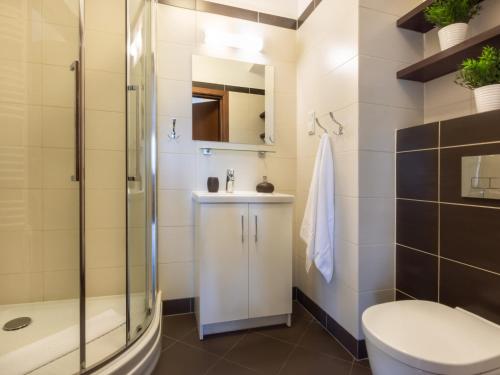 a bathroom with a shower and a toilet and a sink at VacationClub – Aquamarina Apartament C-19 in Świnoujście
