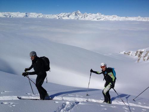 two people on skis in the snow on a mountain at Rauzi Hotel Garnì & apartments in Malè