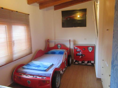 a childs bedroom with a bed in the shape of a car at Villa Maria Louiza NEAR AIRPORT in Artemida