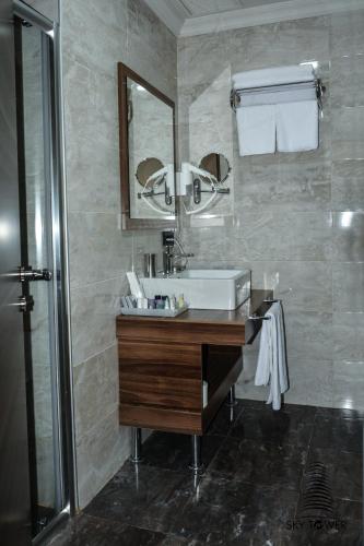 a bathroom with a sink and a mirror at King Sky Tower Hotel in Batumi