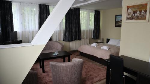 um quarto de hotel com uma cama e uma escada em Szlovák Panzió em Békéscsaba