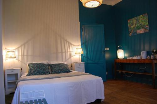 - une chambre avec un lit aux murs bleus dans l'établissement Madeleine Bergerac, à Bergerac