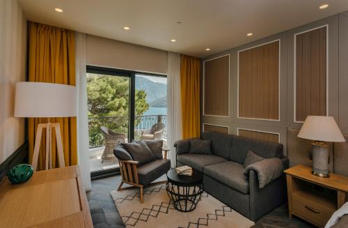 a living room with a couch and a chair and a window at Boutique Hotel & Spa Casa del Mare - Mediterraneo in Herceg-Novi