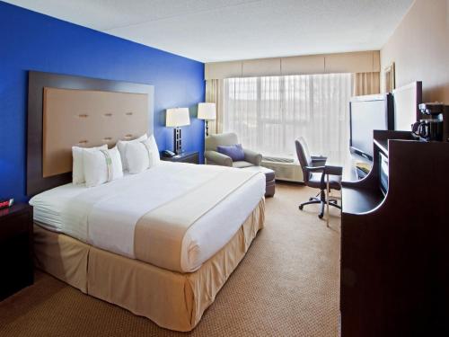 a hotel room with a large bed and a desk at Holiday Inn Washington D.C. - Greenbelt Maryland by IHG in Greenbelt