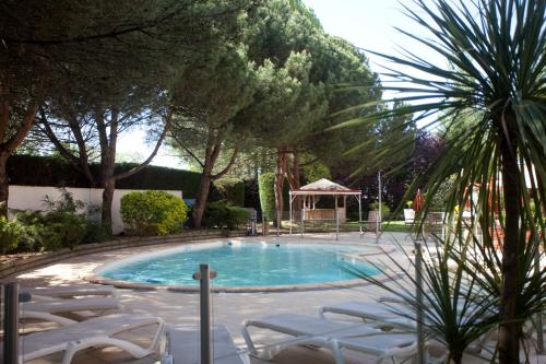 einen Pool mit Stühlen und einem Pavillon in der Unterkunft Mercure Bordeaux Aéroport in Mérignac