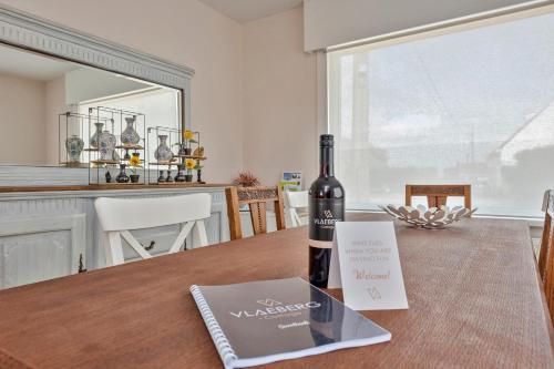 a bottle of wine sitting on top of a table at Vlaeberg Cottage in Kortemark