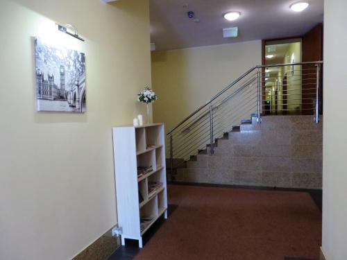 a hallway with a staircase with a painting on the wall at City Apartments Protos in Knurów