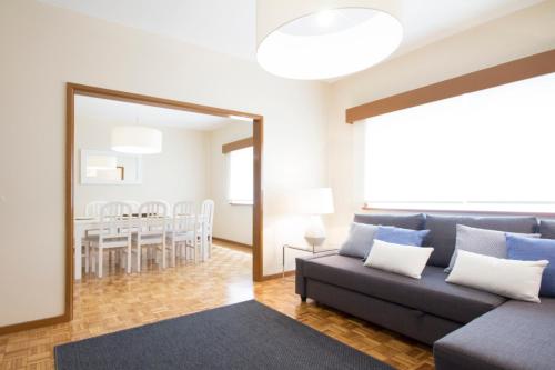 a living room with a couch and a dining room at OHH - Casa da Foz- Near the Beach in Porto