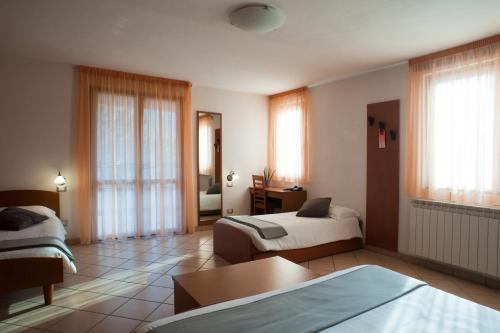 pokój hotelowy z 2 łóżkami i stołem w obiekcie Hotel Oasi Verde w mieście Bienno