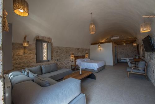 a living room with a couch and a bed at IPPOLA BOUTIQUE HOTEL in Érimos