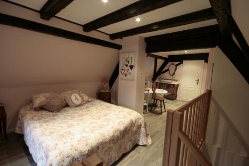 - une chambre avec un lit et un couloir avec une table dans l'établissement Appartement Louise avec Balcon, à Kaysersberg