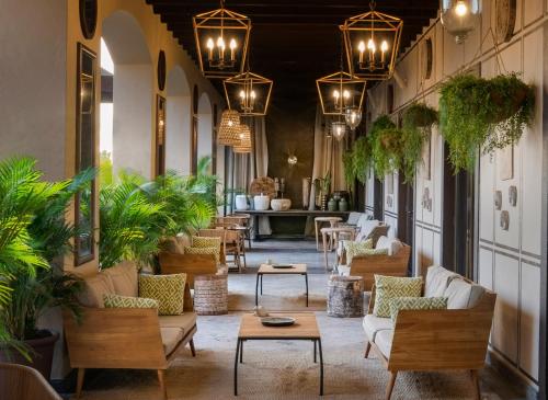a lobby with chairs and tables and potted plants at Vincci Selección La Plantación del Sur in Adeje