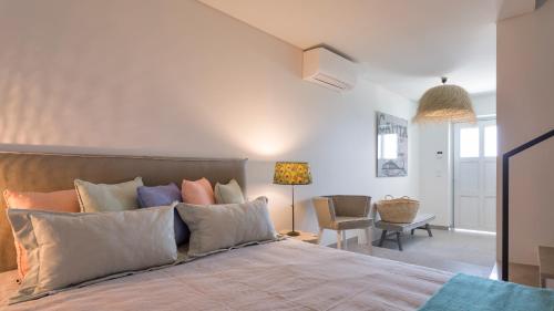 una camera da letto con un grande letto con cuscini di Vila Ninho by Sevencollection a Salema