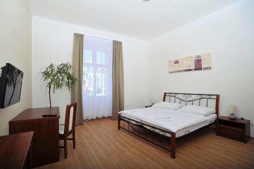 a bedroom with a bed and a table and a chair at Penzion Královské lázně in Poděbrady
