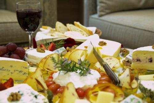a table with cheese and fruit and a glass of wine at Bzommar Palace Hotel in Harisa