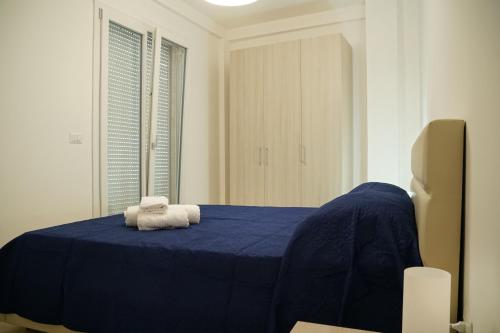 Un dormitorio con una cama azul con toallas. en Casa Vacanze Pirandello, en Torre Lapillo