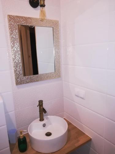 a bathroom with a white sink and a mirror at Fajna Chatka in Ustrzyki Dolne