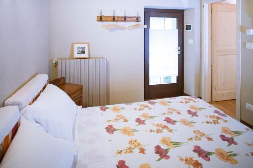 Un dormitorio con una cama con una manta floral. en I Chimi Locanda di Frassino en Frassino