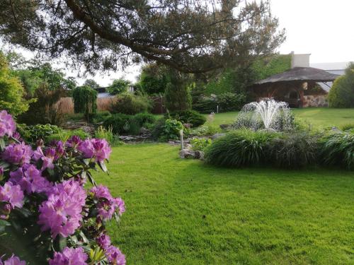 a garden with pink flowers and a fountain at Agro Relax Nowodwór in Nowodwór