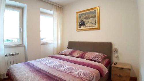a bedroom with a bed and a picture on the wall at Lux Apartment Lazarevic in Zlatibor