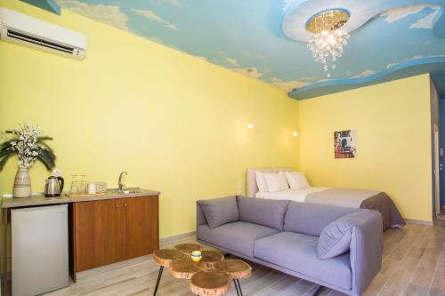 a bedroom with a bed and a purple couch at Haven Beach in Faliraki