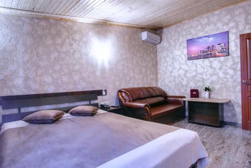 um quarto com uma cama grande e uma cadeira em Hotel Fortuna em Lviv