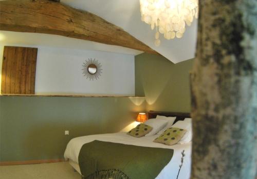 a bedroom with a bed and a chandelier at Maison du figuier in Lancié
