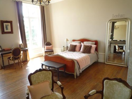 1 dormitorio con cama, espejo y sillas en Château de Plessier-Roza en Le Plessier-Rozainvillers