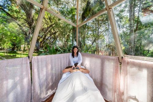 a woman sitting on a wedding dress in a tent at Pousada Cantos e Contos in Monte Verde