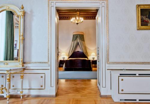 um corredor com uma cama num quarto com um espelho em Grand Hotel em Cracóvia