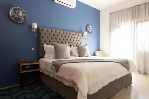 a bedroom with blue walls and a large bed at Marianne Wine Estate in Stellenbosch