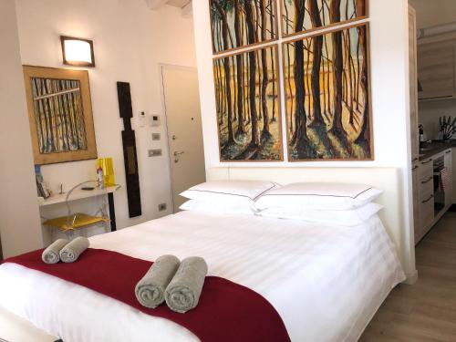 a bedroom with a large white bed with towels on it at Antica Fonte Holiday Homes in San Pantaleo