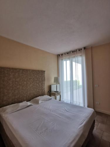 a bedroom with a large white bed with a window at Residence Il Vigneto in Oggebbio