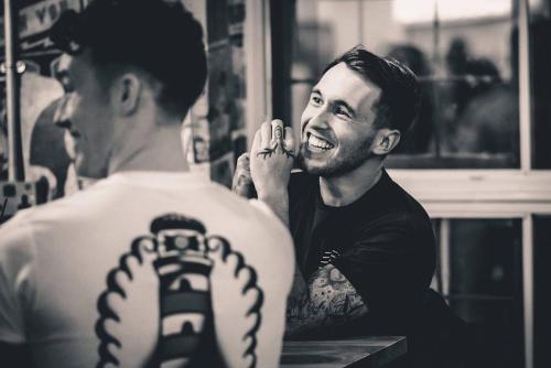 a man getting a tattoo on a mans back at Urban Nomad - Camden Town in London