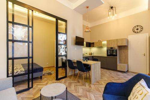 E13 - Elegant Apartment في بودابست: غرفة معيشة مع أريكة زرقاء وطاولة