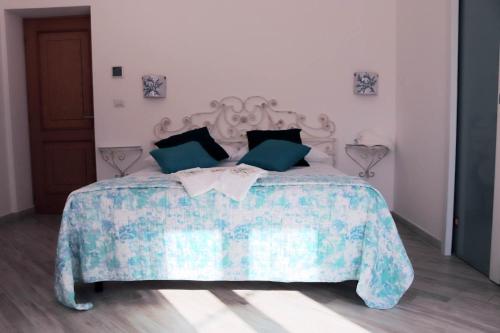 a bedroom with a bed with a blue and white comforter at Clelia's Boutique Rooms & Suites in La Maddalena