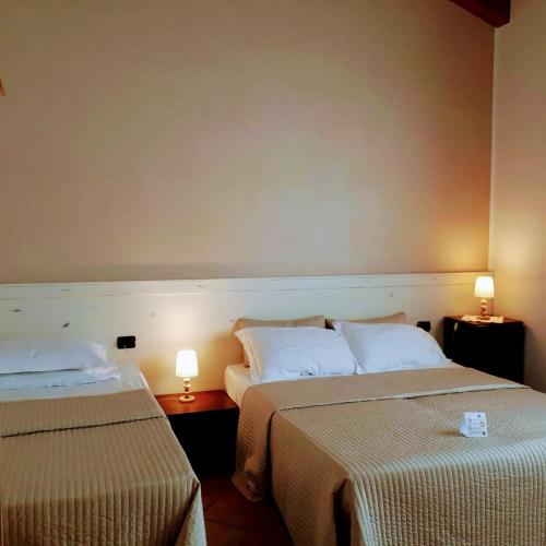 a hotel room with two beds and two lamps at Agriturismo Ai Carpini in Marcon
