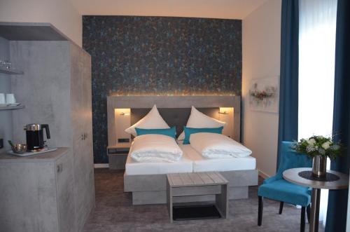 a bedroom with a large bed with a blue wall at Hotel Garni Nordseejuwel in Horumersiel