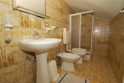 uma casa de banho com um lavatório e um WC em Appartamento trilocale nr. 5 em Livinallongo del Col di Lana