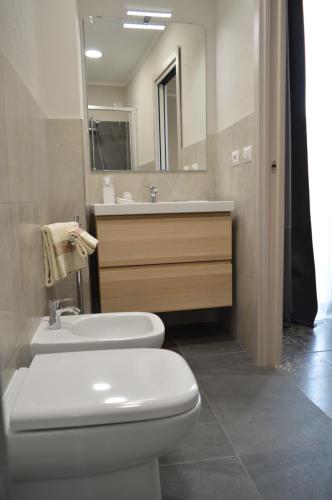 a bathroom with a white toilet and a sink at Musica Guest House in Alghero