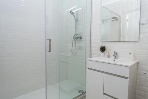 a white bathroom with a shower and a sink at Luz Apartments in Portimão
