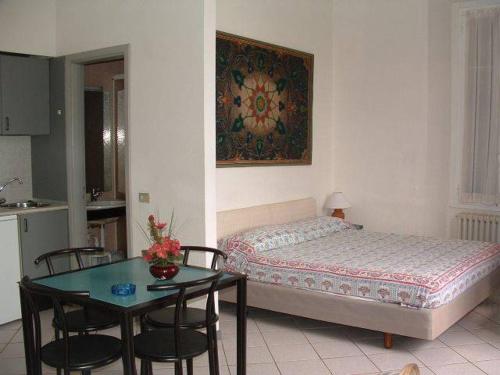 - une chambre avec un lit et une table avec des chaises dans l'établissement Baveno mono, à Baveno