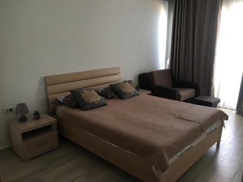 een slaapkamer met een groot bed en een stoel bij Amare&Mare Apartment in Sutomore