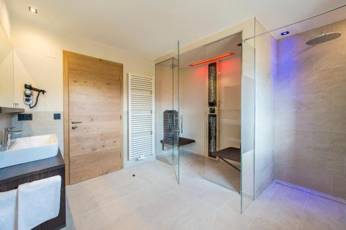 a bathroom with a glass shower and a sink at Hotel Zum Tiroler Adler in Tirolo