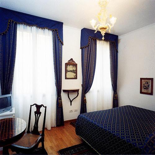 a bedroom with blue and white curtains and a bed at Ca' Angeli in Venice