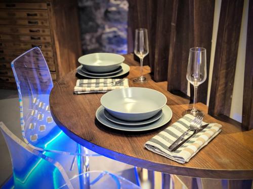 a wooden table with plates and wine glasses on it at Blu Luna in Riomaggiore